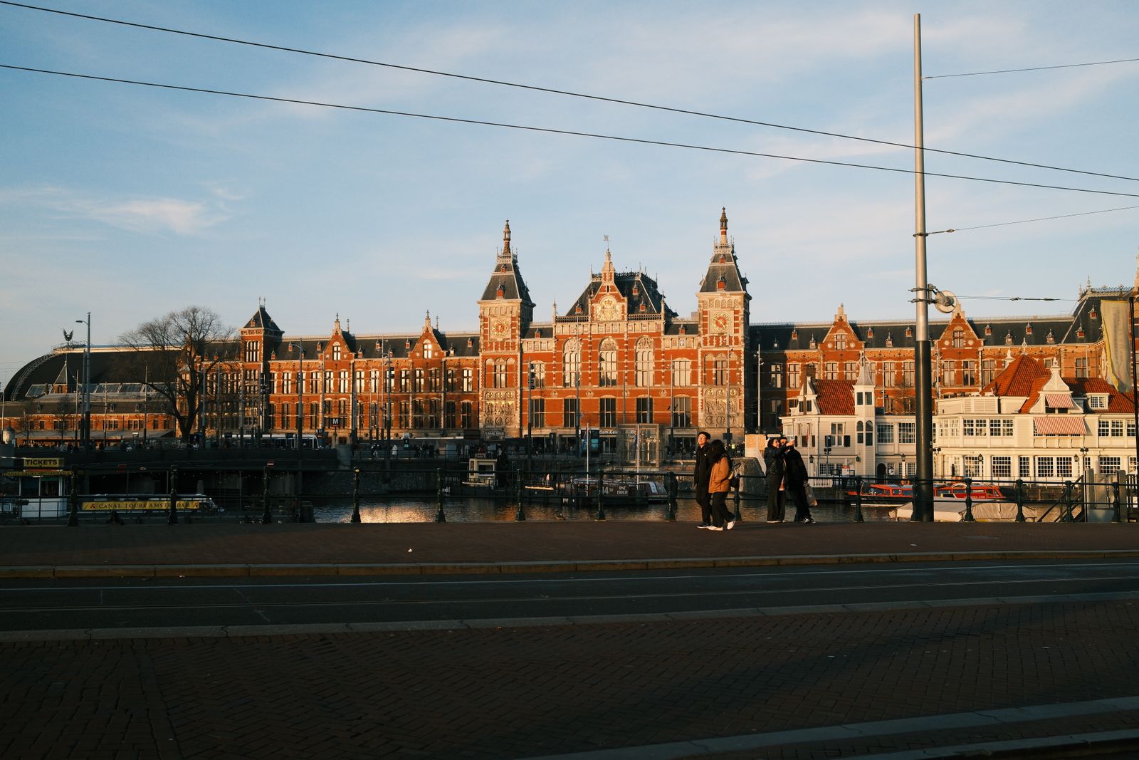 Bakstenen gevels en de Domtoren boven een autovrije straat in het centrum van Utrecht